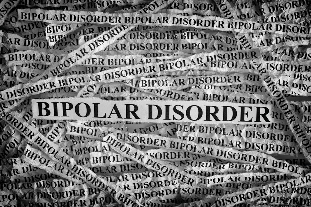 A conceptual black and white image showing multiple strips of paper with the repeated words "BIPOLAR DISORDER," emphasizing the complexity and intensity of the mental health condition.