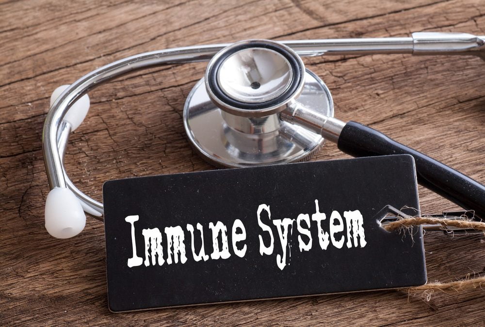 Stethoscope resting on a wooden surface next to a sign labeled "Immune System," symbolizing healthcare and immune health.