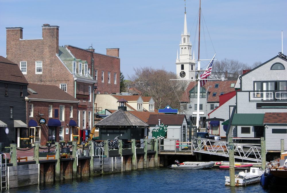 A scenic view of a historic waterfront in a town, featuring a small canal or harbor.