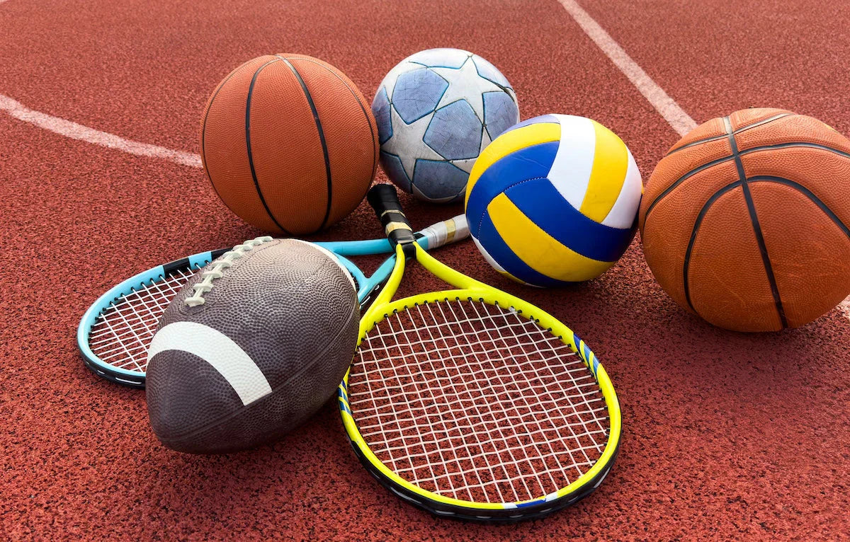Sports balls and equipment on a red track surface