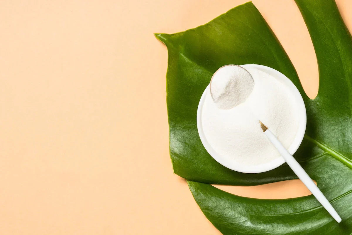 White powder with a green leaf on a beige background