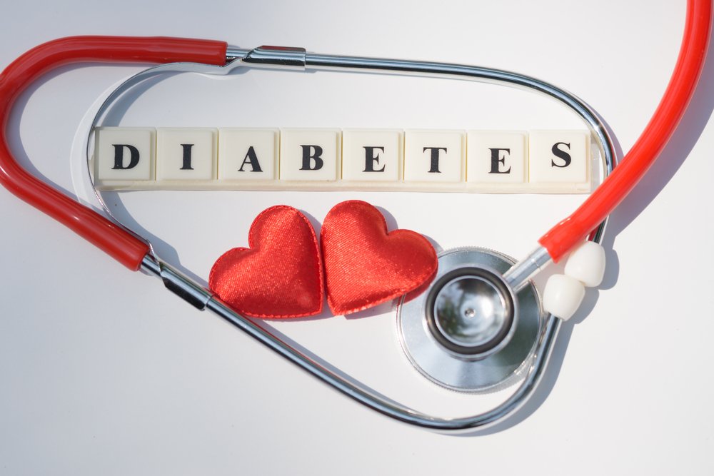 The word DIABETES spelled out across eight white square tiles, framed by a red and silver stethoscope. 