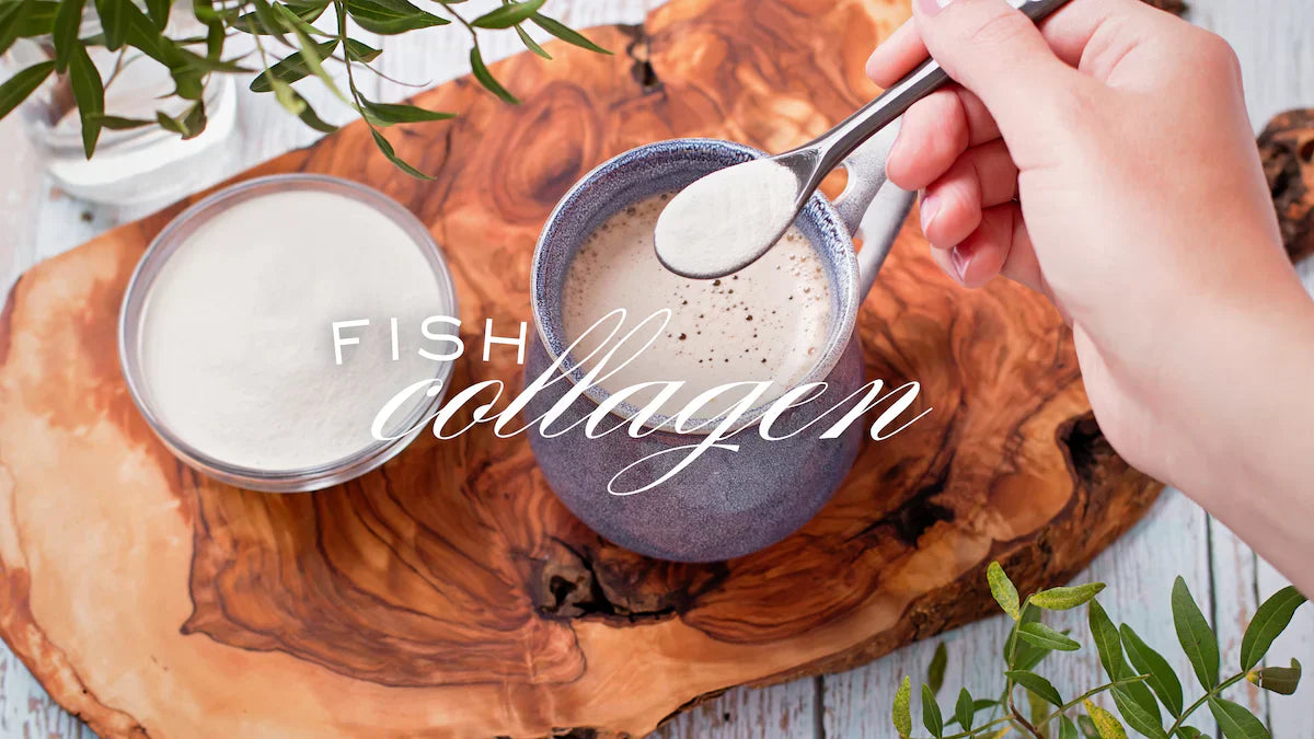 Hand scooping a spoonful of 'Fish Collagen' from a container on a wooden board.
