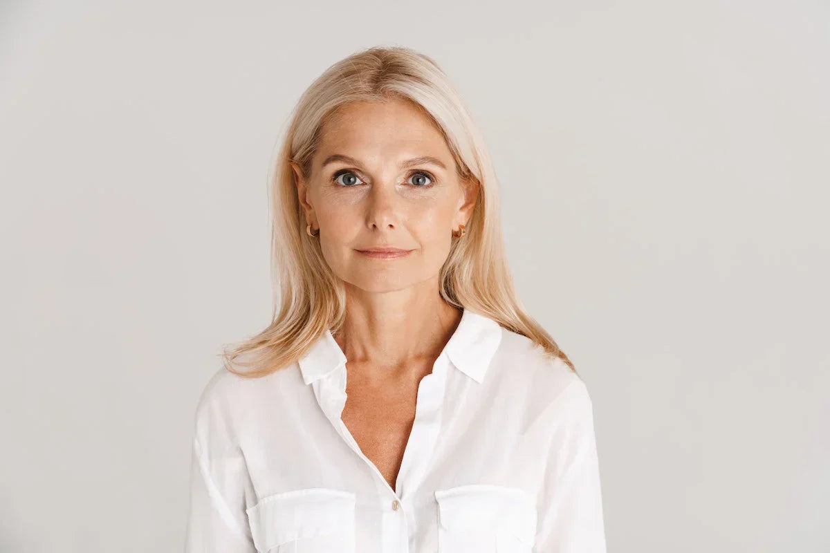 Woman wearing a white shirt against a plain background