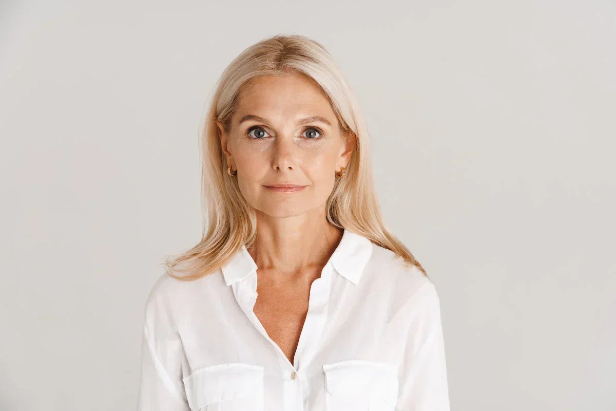 Woman wearing a white shirt against a plain background