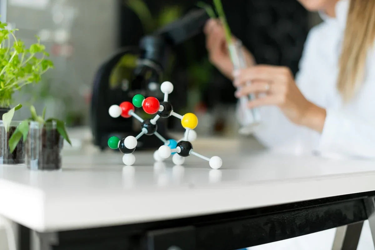 Molecular model on a desk with a person working in the background